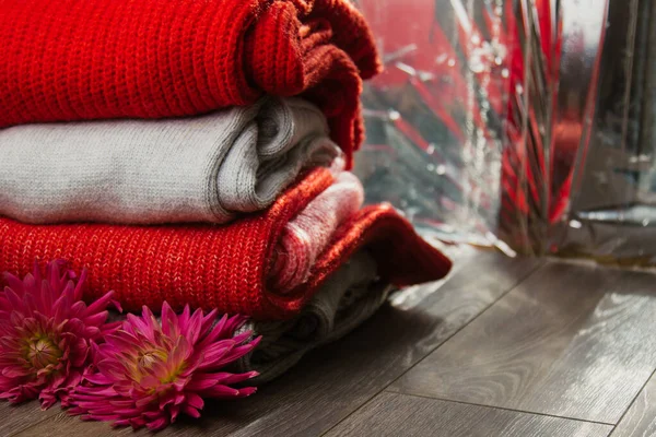 Patroon van kleurrijke gebreide truien close-up. Handgemaakte merino wol product. Een stapel gevouwen kleren met bloemen. — Stockfoto