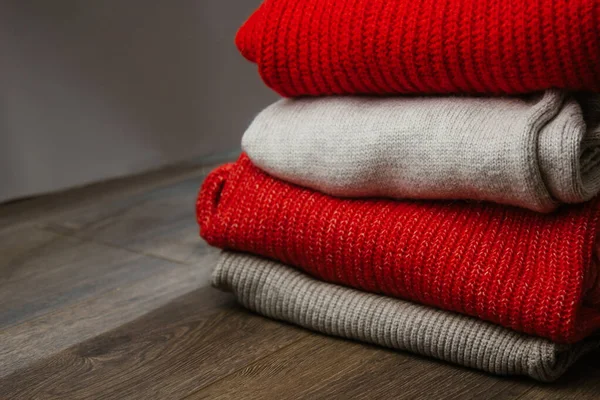 Patroon van kleurrijke gebreide truien close-up. Handgemaakte merino wol product. Een stapel gevouwen kleren met bloemen. — Stockfoto