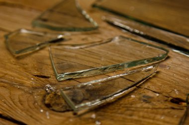 Eski ahşap bir zeminde kırık cam, şiddet kavramı..