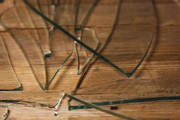 Vidrio roto sobre un viejo suelo de madera, concepto de violencia . — Foto de Stock