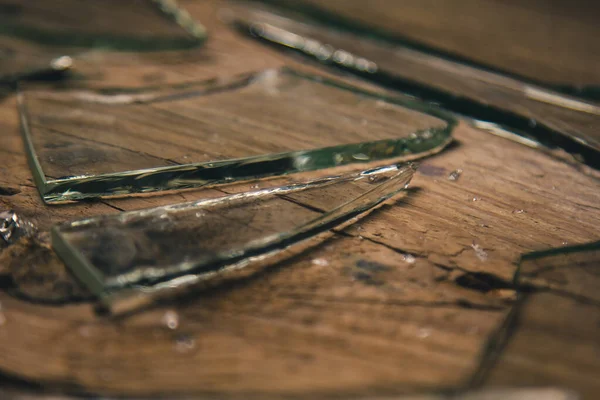 Vidrio roto sobre un viejo suelo de madera, concepto de violencia . — Foto de Stock