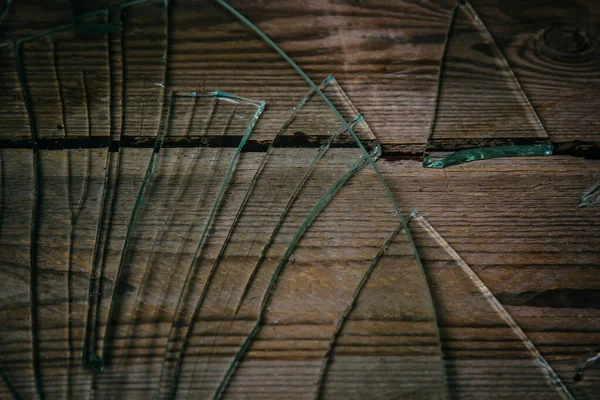 Vidrio roto sobre un viejo suelo de madera, concepto de violencia . — Foto de Stock