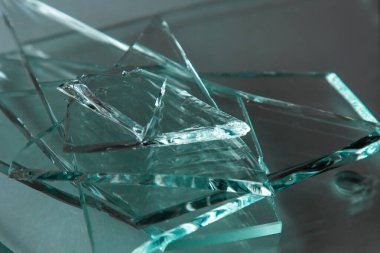 Broken glass background for your images isolated on white. Many large glass fragments scattering from a hammer as a concept of violence. clipart