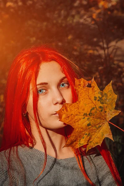 Sexy piękna ruda dziewczyna z długimi, silnymi i grubymi włosami. Idealny portret kobiety na tle jesiennych liści. Piękne głębokie niebieskie oczy. Naturalne piękno, czysta skóra, pielęgnacja twarzy i włosów. — Zdjęcie stockowe