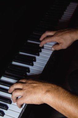 Piyanoda iki erkek eli. avuç içi tuşları üzerinde yalan ve müzik okulunda klavye liç. öğrenci oynamayı öğrenir. eller piyanist. siyah koyu arka plan.
