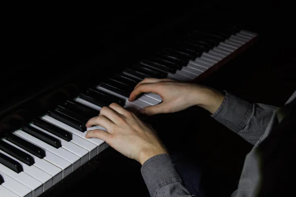 Two male hands on the piano. palms lie on the keys and play the keyboard instrument in the music school. student learns to play. hands pianist. black dark background. — Stock Photo, Image