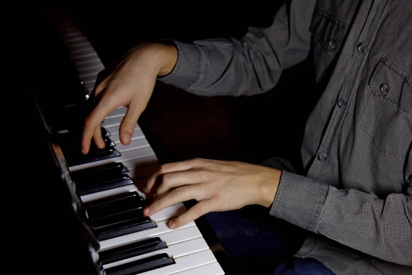 Two male hands on the piano. palms lie on the keys and play the keyboard instrument in the music school. student learns to play. hands pianist. black dark background. — Stock Photo, Image