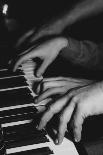 Négy férfikéz zongorázik. tenyér fekszik a billentyűket, és játszani a billentyűzet eszköz egy zeneiskolában. A diák megtanul játszani. egy zongorista keze. fekete sötét háttér. — Stock Fotó