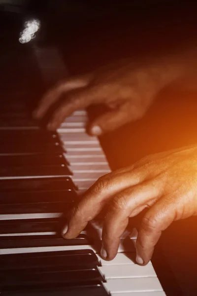 Piyanoda iki erkek eli. avuç içi tuşları üzerinde yalan ve müzik okulunda klavye liç. öğrenci oynamayı öğrenir. eller piyanist. siyah koyu arka plan. — Stok fotoğraf