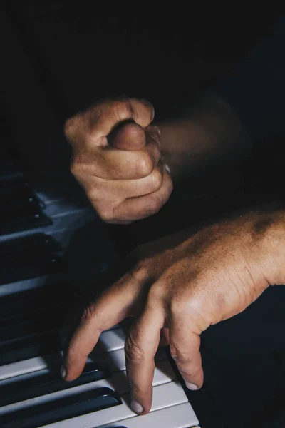 Dos manos masculinas en el piano. las palmas yacen en las teclas y tocan el instrumento de teclado en la escuela de música. estudiante aprende a jugar. manos pianista. fondo negro oscuro . — Foto de Stock