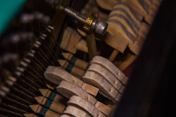 Sluiten van oude kapotte stoffige piano van binnenuit. Hamers in verlaten piano slaan op snaren. Muziek van de oude geruïneerde piano. De hamer van het koord open mechanisme. — Stockfoto