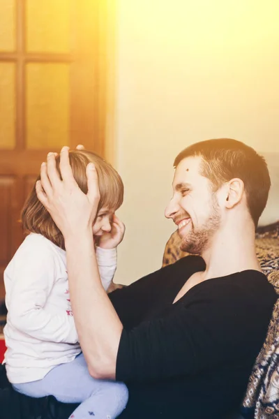 Una niña sonriente de un año abraza a un padre. Fondo de color. Juegos educativos para niños. Pasatiempo creativo de papá y su hija . — Foto de Stock