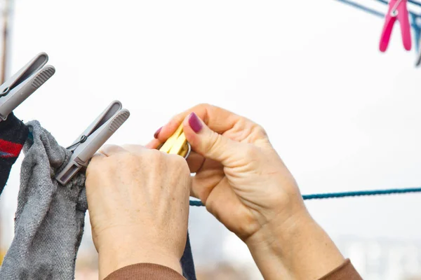 Wasserij vrouw hangt schone natte doek op wasdroger na het wassen thuis. Huishoudelijke taken en huishouding. — Stockfoto