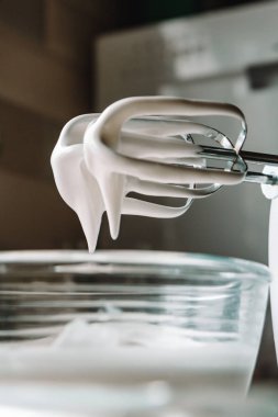 Pişirme konsepti. Cam bir kasede mükemmel doruklar için çırpılmış yumurta beyazı, mermer beyaz bir masada mikser. Kurabiye tarifi.