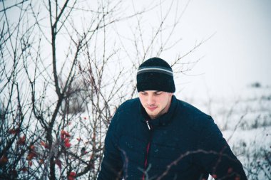 Snowboard yapan mutlu genç adam karlı dağlarda güneşli havanın tadını çıkarıyor. Kış sporu ve eğlence, açık hava aktiviteleri..
