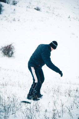 Snowboard yapan mutlu genç adam karlı dağlarda güneşli havanın tadını çıkarıyor. Kış sporu ve eğlence, açık hava aktiviteleri..