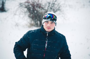 Snowboard yapan mutlu genç adam karlı dağlarda güneşli havanın tadını çıkarıyor. Kış sporu ve eğlence, açık hava aktiviteleri..