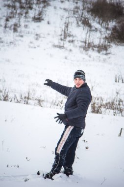 Snowboard yapan mutlu genç adam karlı dağlarda güneşli havanın tadını çıkarıyor. Kış sporu ve eğlence, açık hava aktiviteleri..