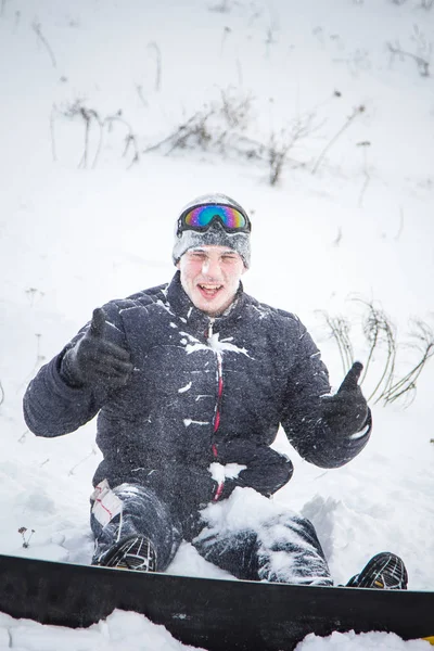 Joven feliz con snowboard disfrutando de un clima soleado en montañas nevadas. Deportes de invierno y recreación, ocio actividades al aire libre . —  Fotos de Stock