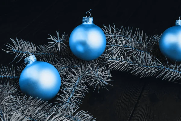 Navidad o Año Nuevo juguetes decoraciones bolas de oro y rama de árbol de piel rústico sobre fondo de madera, vista superior, espacio de copia. Color del año 2020 azul clásico. concepto de tendencia de color pantone de moda . — Foto de Stock