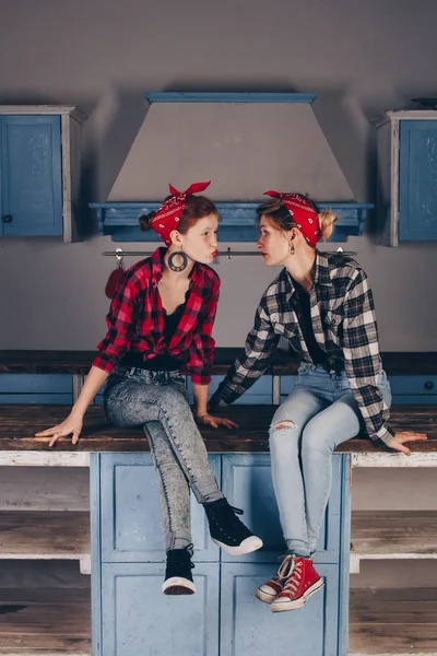 Family, friendship and people concept - happy mother with little daughter. With red lips in a bandana have fun in the home kitchen. Pin-up style photo.
