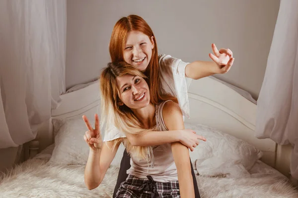 Szczęśliwego Dnia Matki. Mama i jej córka bawią się w dziewczynę, uśmiechając się i przytulając w łóżku. Wakacje rodzinne i wspólne spędzanie czasu. — Zdjęcie stockowe