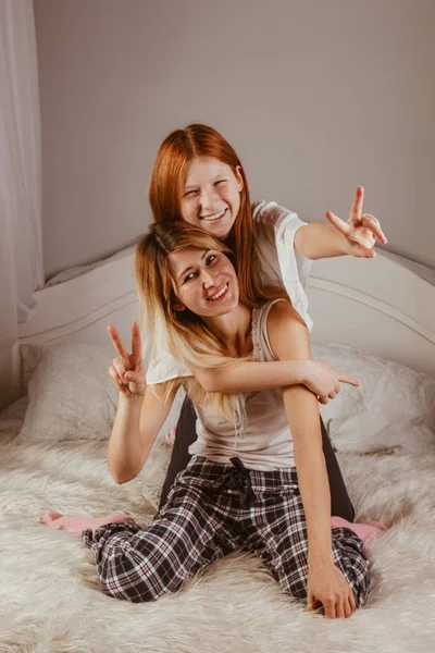 Feliz día de la madre. Mamá y su hija están jugando a las chicas, sonriendo y abrazándose en la cama. Vacaciones en familia y unión . — Foto de Stock