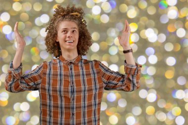 Kutlama, insanlar ve tatil konsepti. Mutlu kıvırcık adam, arka planda Noel ya da yeni yıl partisi veriyor..