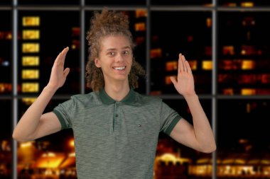 Kutlama, insanlar ve tatil konsepti. Mutlu kıvırcık adam, arka planda Noel ya da yeni yıl partisi veriyor..