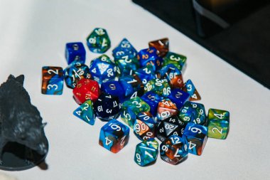 Masa oyunları için zarlar, dand ve RPG ışık yüzeyine saçılmış.
