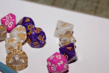 Masa oyunları için zarlar, dand ve RPG ışık yüzeyine saçılmış.