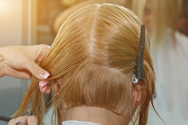 Žena se středně dlouhými blond vlasy. S krátkým sestřihem u kadeřníka u kadeřníka, který používá nůžky. Péče. Pán si zkrátí vlasy.. — Stock fotografie
