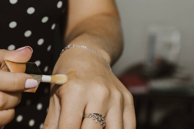 Makyöz pembe ruj sürüyor. Güzel bir kadın yüzü. Makyaj ustasının eli genç bir kızın dudaklarını boyuyor. Makyaj devam ediyor.