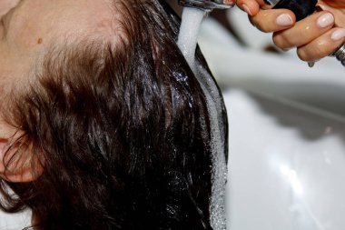 Güzel, neşeli, yaşlı bir kadın saçını profesyonel bir kuaför tarafından yıkarken kafa masajından hoşlanıyor. Güzellik, saç stili, moda, yaşam tarzı cazibe konsepti. Bir damla su ve şampuan köpüğü..