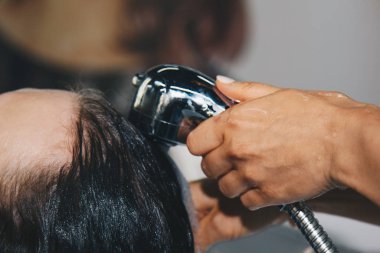 Güzel, neşeli, yaşlı bir kadın saçını profesyonel bir kuaför tarafından yıkarken kafa masajından hoşlanıyor. Güzellik, saç stili, moda, yaşam tarzı cazibe konsepti. Bir damla su ve şampuan köpüğü..