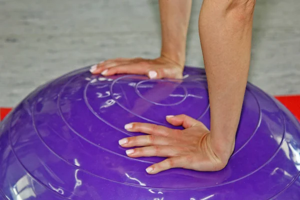 Mooie jonge vrouw fitness in de sportschool doen. Meisje gebruikt fitball oefening, expander, halfrond. — Stockfoto