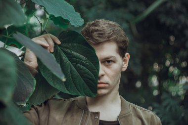 Kendinle birlik. Göz alıcı çekici adam kameraya bakıyor ve onun baş çok arka plan üzerinde poz devirme.