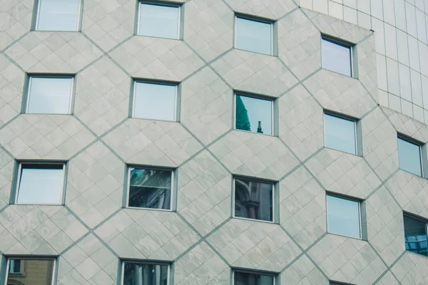 Fondo geométrico con muchas filas de ventanas. Estructura moderna del edificio. Muchos vasos en una enorme pared. Rascacielos europeo clásico con espacio para copias . — Foto de Stock