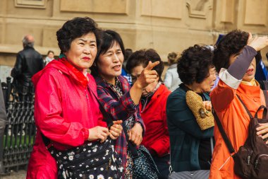 Prag 'da. 10.05.2019: Asyalı turistler şehrin ana caddesinde yürüyorlar. Yoldan geçenler manzaranın fotoğrafını çeker ve selfie çeker..
