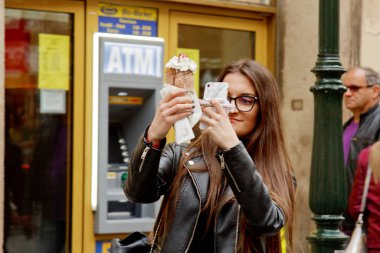 Prag 'da. 10.05.2019: Asyalı turistler şehrin ana caddesinde yürüyorlar. Yoldan geçenler manzaranın fotoğrafını çeker ve selfie çeker..