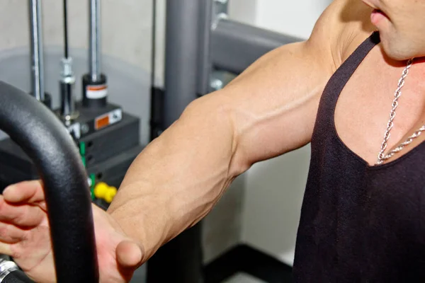 Male powerful biceps closeup. Gym. Body-builder. Beautiful, swollen male body. Trainer, advertising, healthy lifestyle. Bodybuilder. The concept of sports