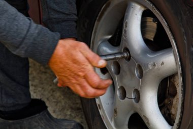 Elektrikli tornavida dışında lastik değiştirme otomatik mekanik adam. Araba servisi. Elleri Lastik tekerlekli yerine. Lastik yükleme kavramı