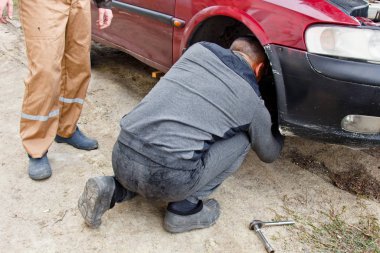 Hizmet süreci. Garajda lastik tutan bir adam var. Kış ve yaz lastikleri değiştiriliyor. Mevsimlik lastik değiştirme kavramı
