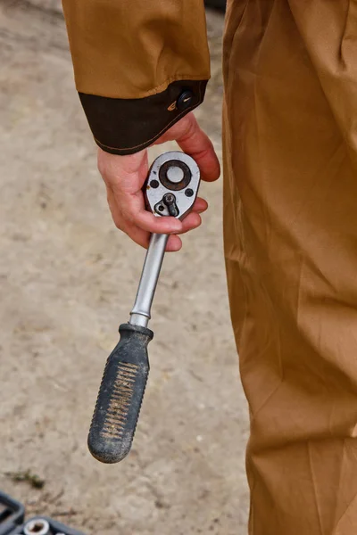 Auto mechanic man with electric screwdriver changing tire outside. Car service. Hands replace tires on wheels. Tire installation concept