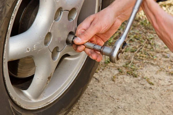 Service process. A man holds a tire in the garage. Replacing winter and summer tires. Seasonal tire replacement concept