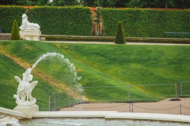 Viyana, Avusturya - 11, 05, 2019: Bulutlu bir yaz günü. Belvedere bahçeleri, gölleri, çeşmeleri, perileri ve arka planda Belvedere sarayı olan bir imparatorluk barok parkı.