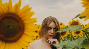 Ayçiçeği çiçekli, güzel ve seksi bir kızın yakın plan portresi. Zevk duygusu, özgürlük konsepti, yaşam tarzı. Kameraya bak.