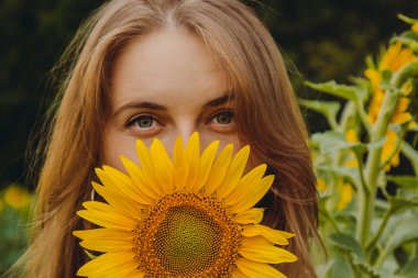 Sarışın ve ayçiçeği çiçekli güzel, tatlı, seksi bir kızın yakın plan portresi. Zevk duygusu, özgürlük konsepti, yaşam tarzı. Kameraya bak.