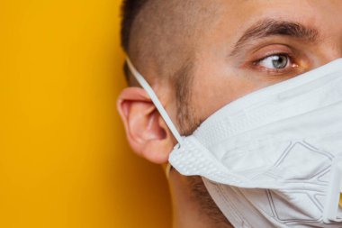 Koronavirüs karantinası sırasında tıbbi maske takan sakallı beyaz bir adamın fotoğrafını çek. Yüzün ön kısmı hafifçe bulanıklaştı. Coronavirus, COVID-19 salgını. Doktor, hemşire konsepti