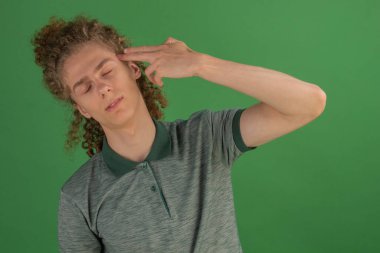 Yakışıklı, genç bir adam parmağını şakağına tutuyor. Vesikalık fotoğraf. Bir adamın hayatındaki sorunlar. İntihar düşüncesi.